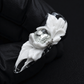 Decorative ring with floral design and gemstone on a black background