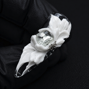 Decorative ring with floral design and gemstone on a black background
